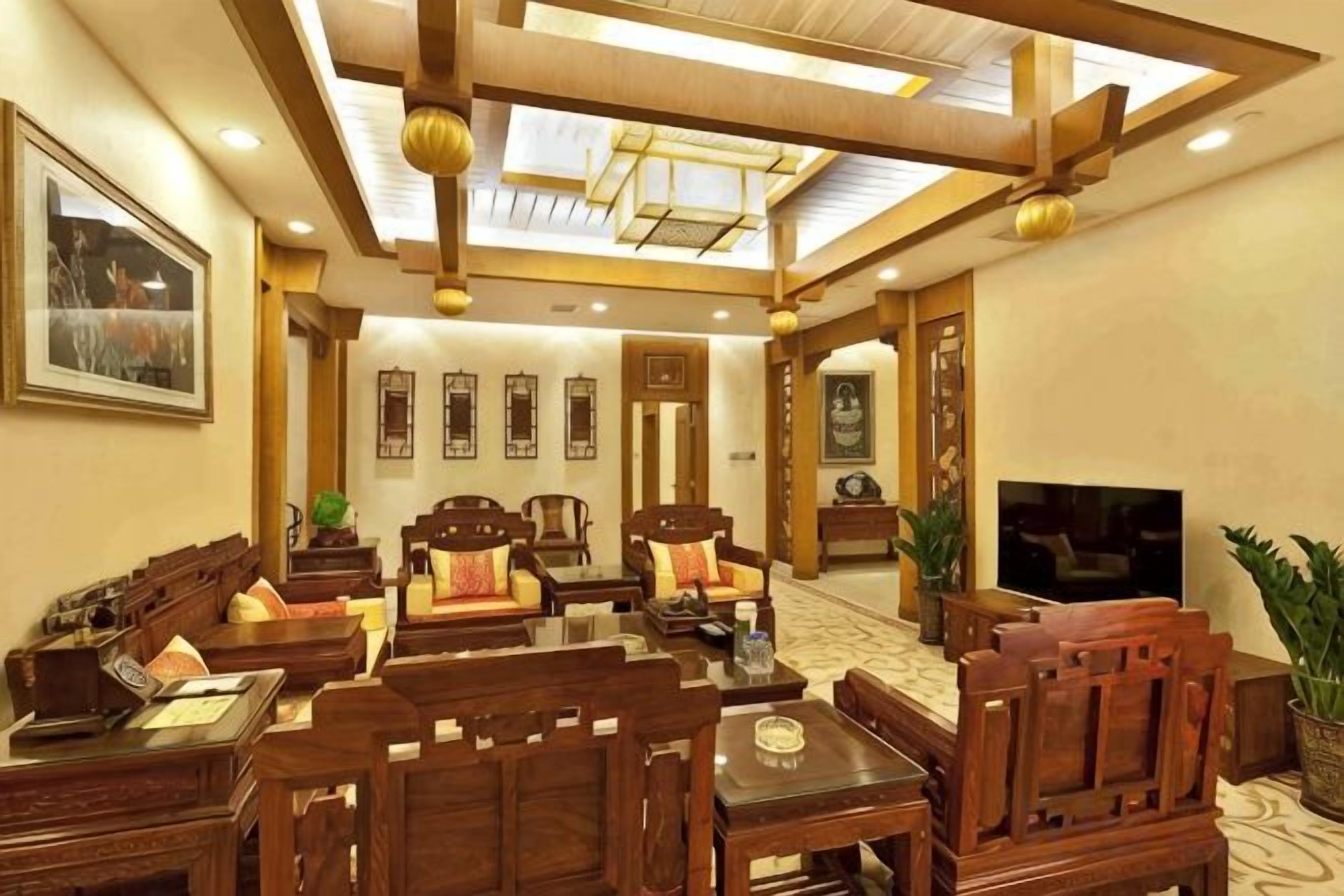 Un salón comedor de estilo tradicional con muebles de madera, un televisor de pantalla plana y un ventilador de techo.