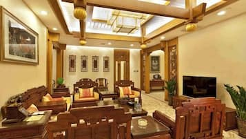Un salón comedor de estilo tradicional con muebles de madera, un televisor de pantalla plana y un ventilador de techo.