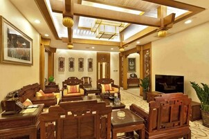 Un salón comedor de estilo tradicional con muebles de madera, un televisor de pantalla plana y un ventilador de techo.