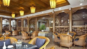 Restaurante de estilo tradicional com mobiliário de madeira, mesas e lanternas penduradas.