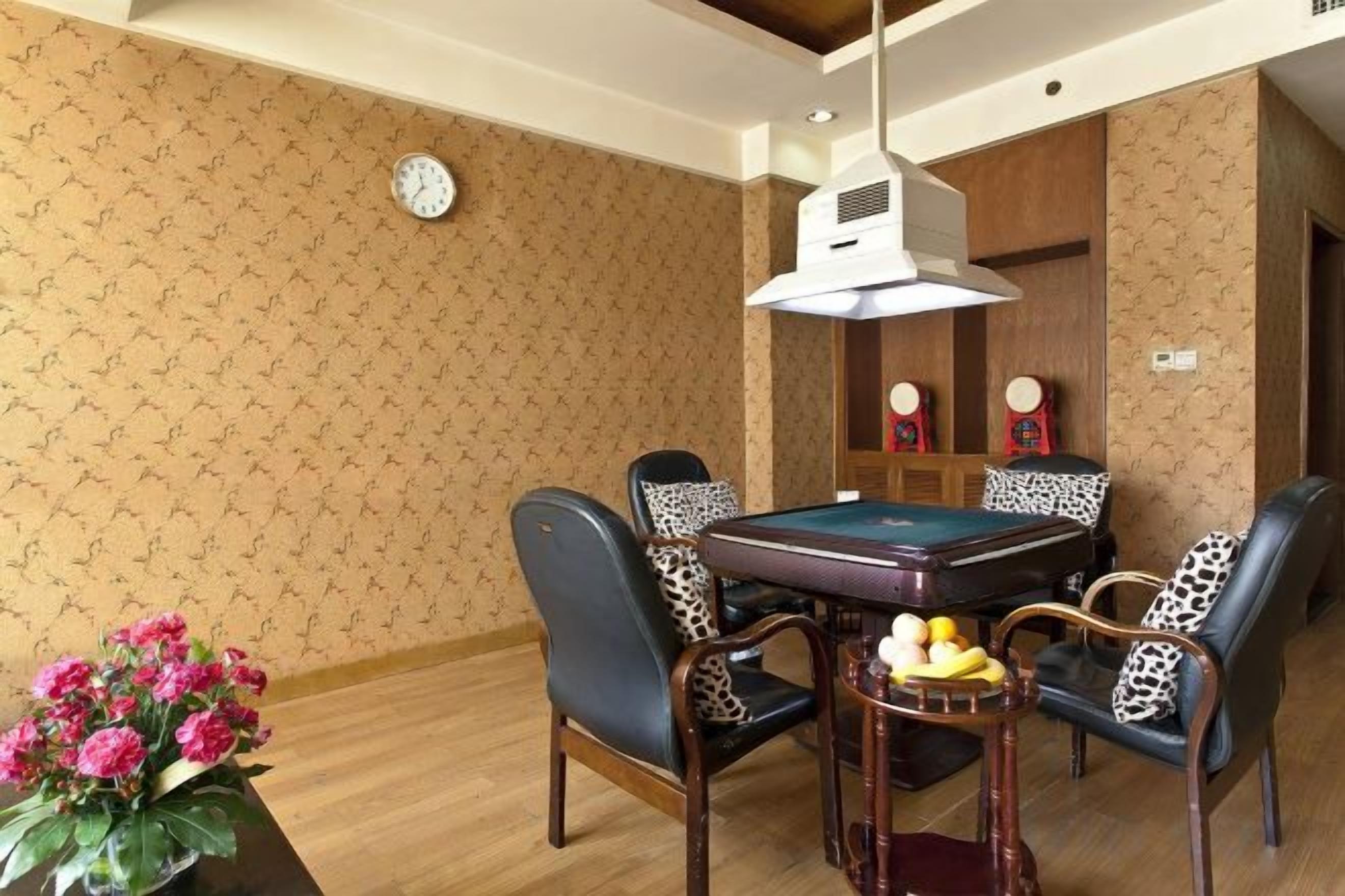 Un área de comedor con mesa de billar, sillas y un reloj en la pared.