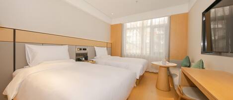 A hotel room with a large bed, a desk, and a chair.