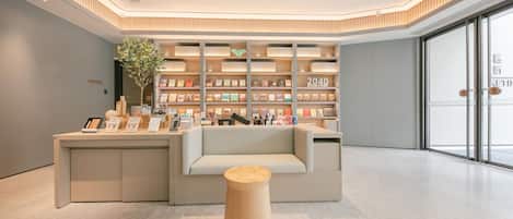 A modern, well-lit bookstore with a central seating area, a large bookshelf, and a minimalist design.
