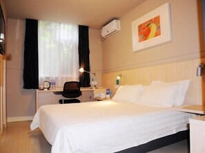 A hotel room with a bed, a desk, a chair, an air conditioning unit, and a painting on the wall. - Jinjiang Inn Quanzhou Kaiyuan Temple (Quanzhou)