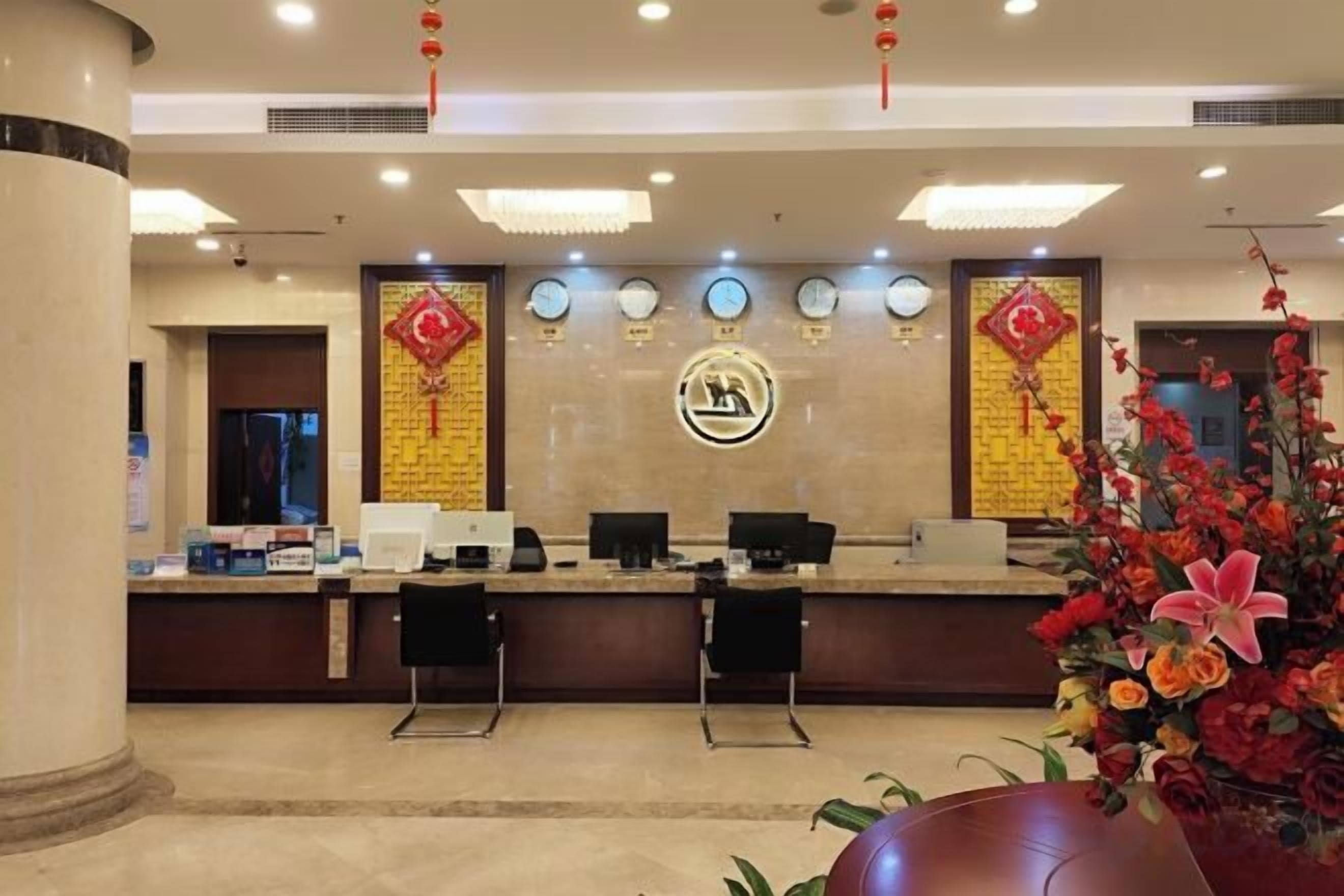 A reception area with a counter, chairs, and a decorative wall with a logo.