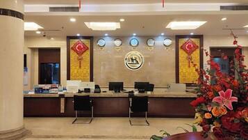A reception area with a counter, chairs, and a decorative wall with a logo.