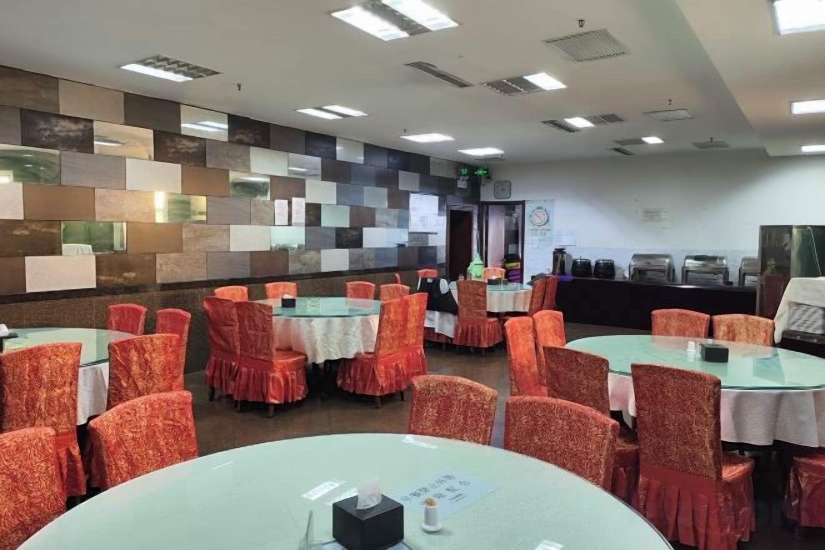 A conference room with round tables and chairs, a projector, and a presentation screen.