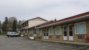 Una hilera de edificios de motel con un estacionamiento al frente.