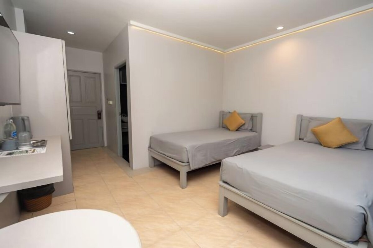 Una habitación de hotel con dos camas individuales, un escritorio pequeño y una silla.
