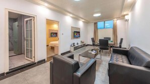 A modern hotel room with a sofa, a coffee table, a TV, and a bathroom visible through an open door. - Xi Yue Hotel（Guangzhou Changlong Nancun area） (Guangzhou)
