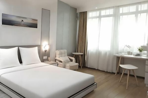 Une chambre dâhĂŽtel avec un lit, un bureau, une chaise et une petite table.