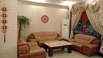 A living room with a sofa set, a coffee table, and a decorative wall hanging.