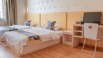 Una habitación de hotel con dos camas, un escritorio con computadora y una silla.
