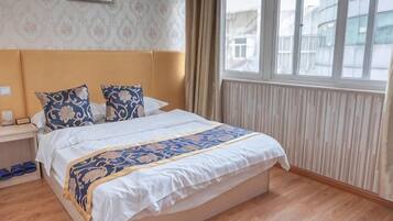 Een hotelkamer met een groot bed, een nachtkastje, een raam met uitzicht en een kamer met een patroon op de muur.