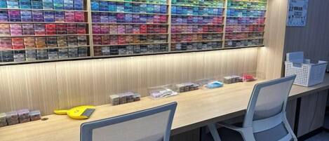 A reception desk with a wall of colorful gift boxes, two chairs, and a sign on the wall.