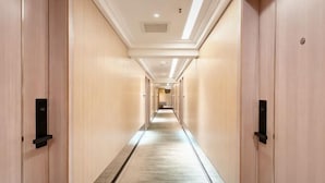 A long, narrow hotel corridor with wooden walls and a tiled floor. - LinghangHostel (Shenzhen)