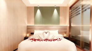 A modern bedroom with a bed, a nightstand, a wall-mounted light, and a large window with blinds. - LinghangHostel (Shenzhen)