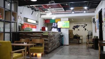 Un restaurant avec des meubles en bois, un comptoir et une carte du monde accrochée au mur.