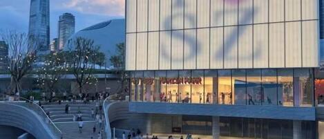 A modern building with a curved facade, multiple levels, and a large glass entrance.