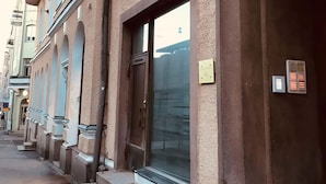 Une rangée de bâtiments dotés d’entrées en arc de cercle et de grandes fenêtres, ce qui laisse supposer un style architectural historique ou traditionnel.