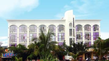 A multi-story building with a symmetrical facade, large windows, and a central entrance.