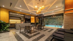 A hotel lobby with a reception desk, seating area, and a pool. - Teymur Continental Hotel (Gaziantep)
