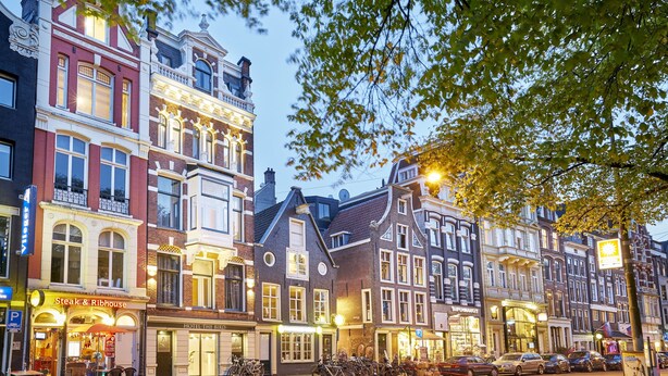 A row of historic buildings with a restaurant named "Steak & Ribhouse" on the ground floor. - Hotel The Bird (Amsterdam)