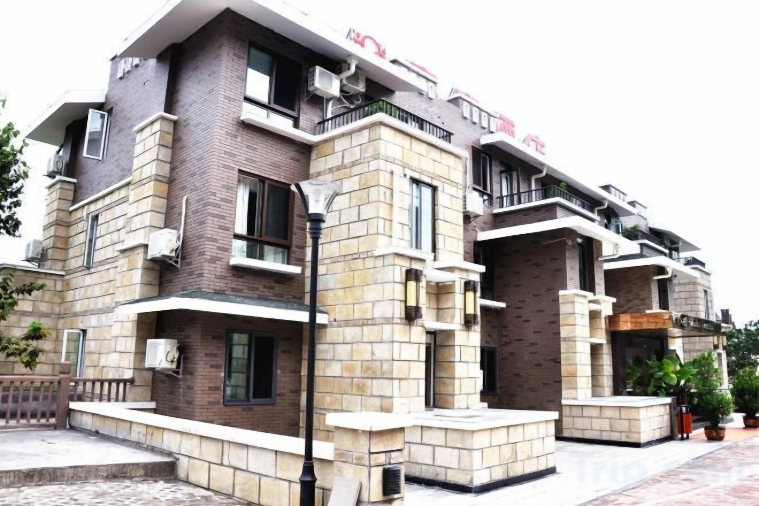 Un edificio de varios pisos con fachada de ladrillo, balcones y unidades de aire acondicionado.