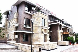 Un edificio de varios pisos con fachada de ladrillo, balcones y unidades de aire acondicionado.