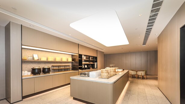 Une cuisine moderne dotée d’un îlot central, d’appareils électroménagers intégrés et d’un coin repas avec des chaises.