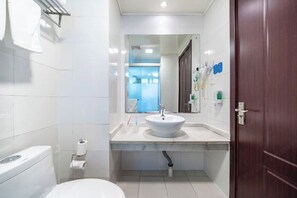 Een moderne badkamer met een wit wastafel, toilet en spiegel.