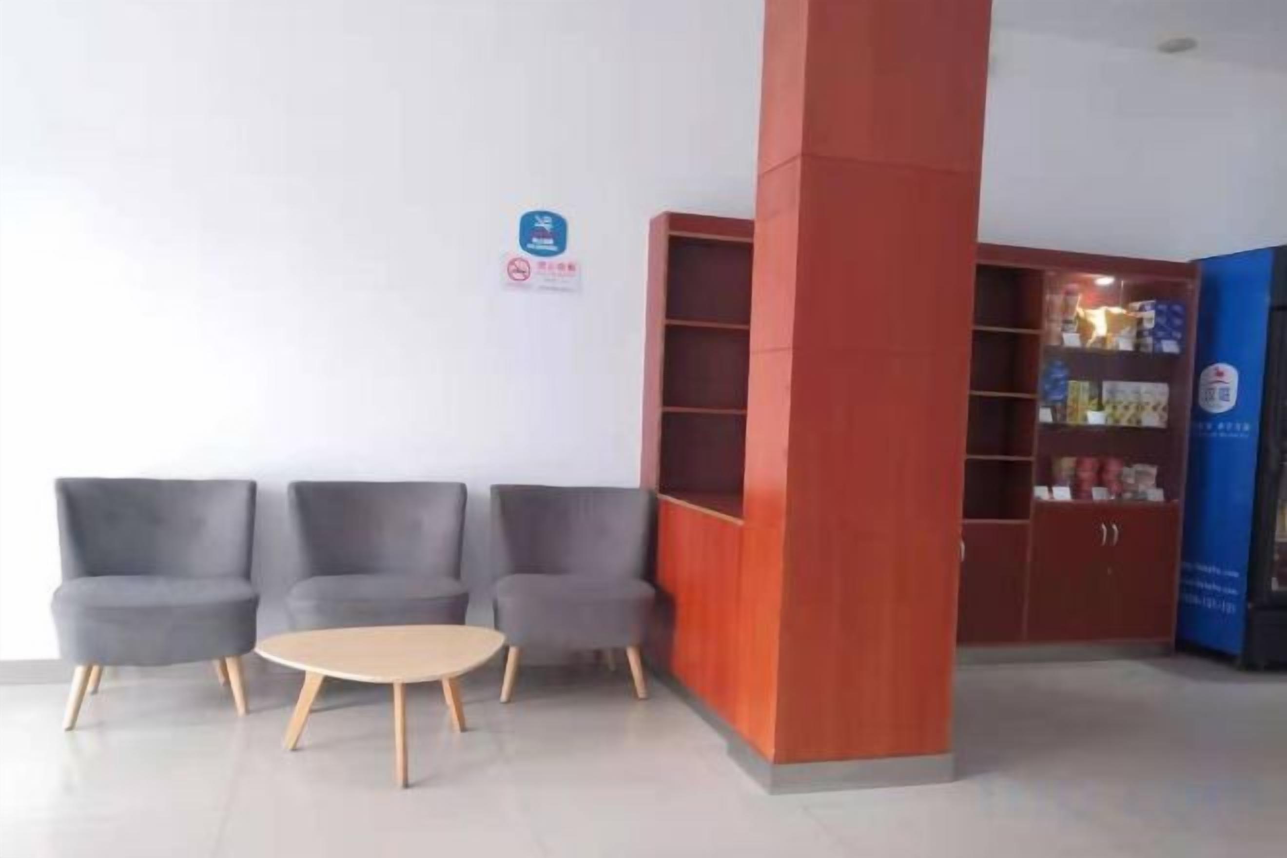 A reception area with a seating arrangement, a pillar, and a bookshelf.