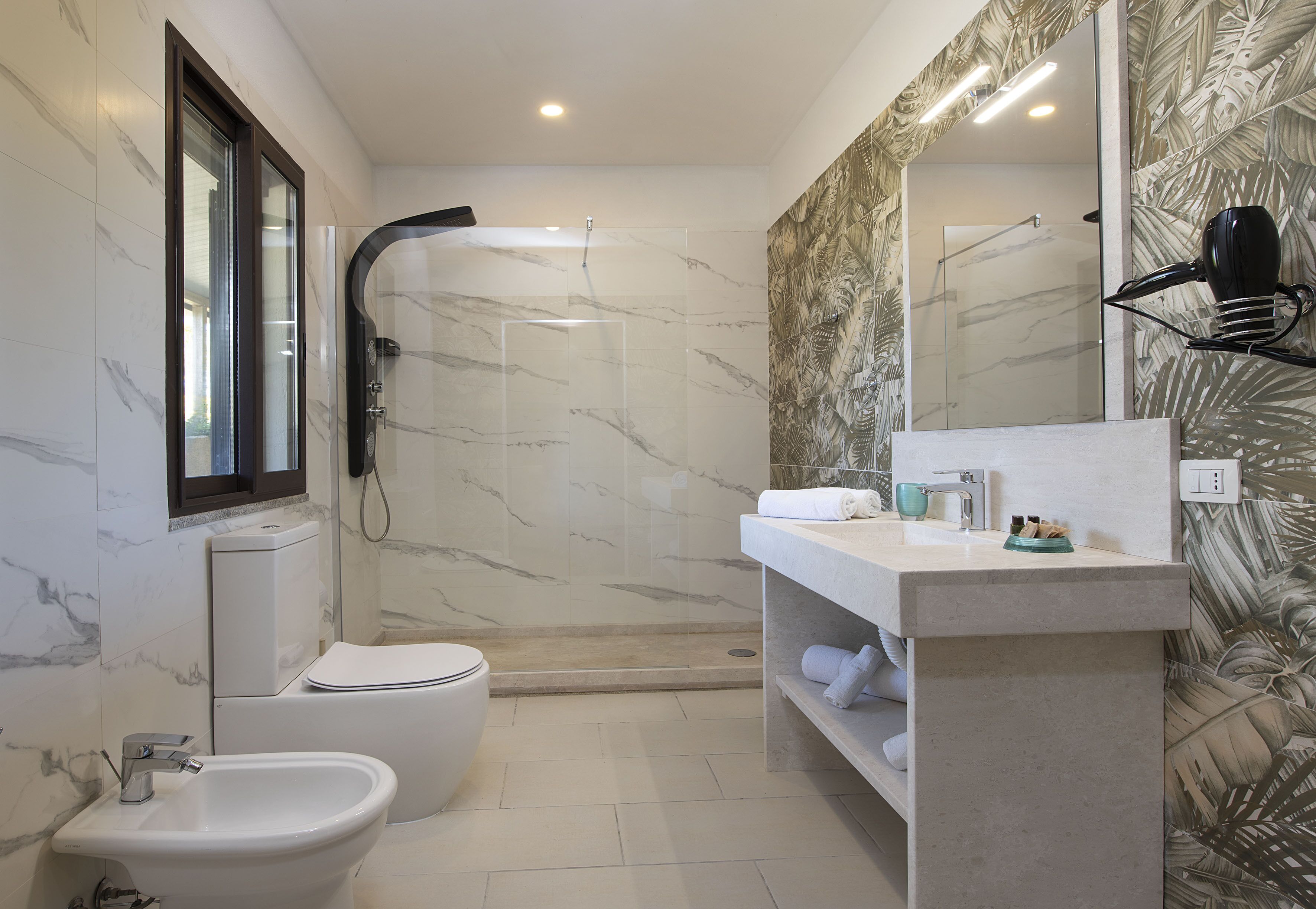 Un baño moderno con bidé, inodoro y ducha.