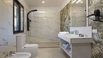 A modern bathroom with a bidet, toilet, and shower.