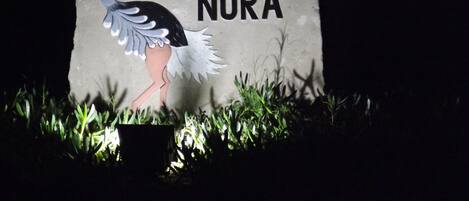 A stone sign with a bird illustration and the text "Hotel Rurale Ortì Di Nora."