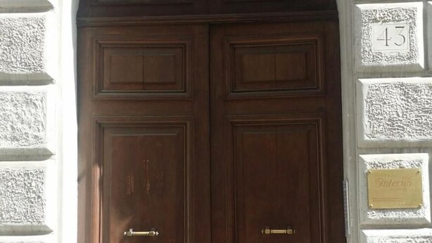 A double wooden door with a metal handle, set in a white stone building with a number plaque '43' on the wall. - Guest house Interno 7 Luxury Rooms (Rome)