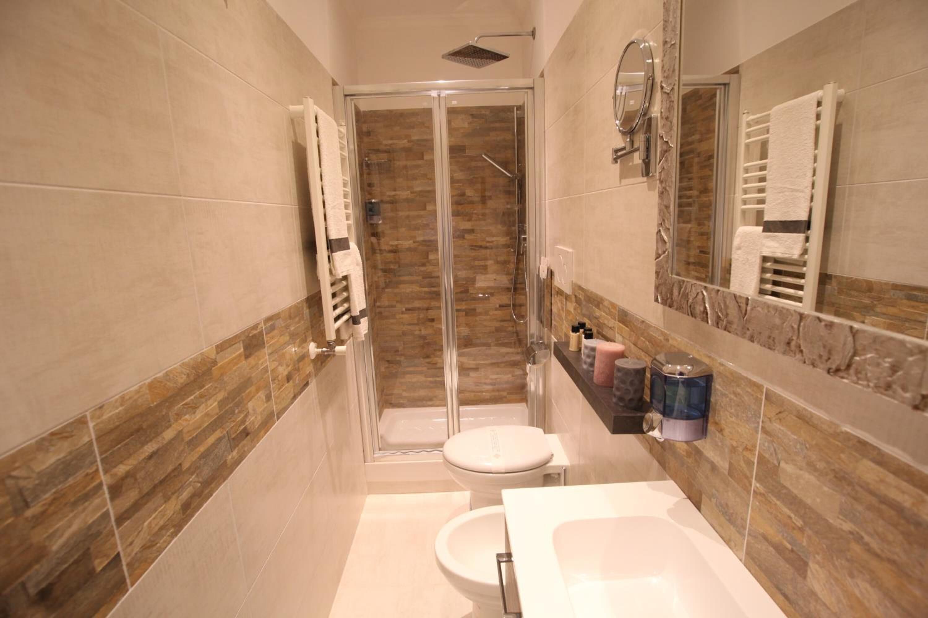 A modern bathroom with a glass-enclosed shower, a white toilet, and a white sink.