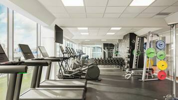 A gym with treadmills, elliptical machines, and weightlifting equipment.