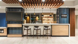 A modern bar area with a wooden ceiling, bar stools, and a TV screen. - Courtyard by Marriott Lima Miraflores (Lima)