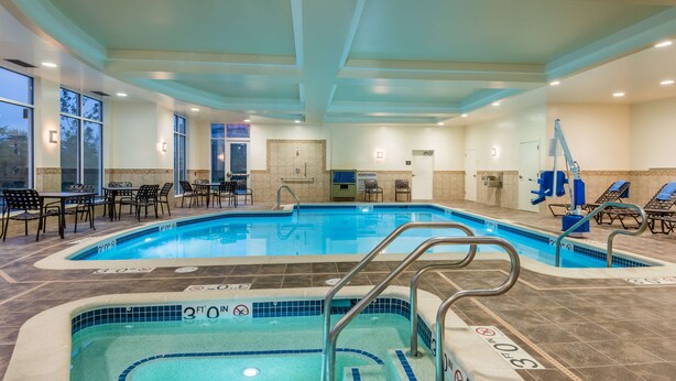 Una piscina interior con varias pistas de natación, vestuario y sillones de descanso.