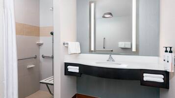 A modern bathroom with a shower, a sink, and a mirror.