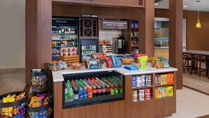 Una tienda llamada 'The Shop' con una variedad de productos, incluyendo bebidas frías, aperitivos y café.