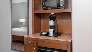 Een kitchenette met een magnetron, een Keurig koffiezetapparaat en een koffiekop met het Hilton logo.