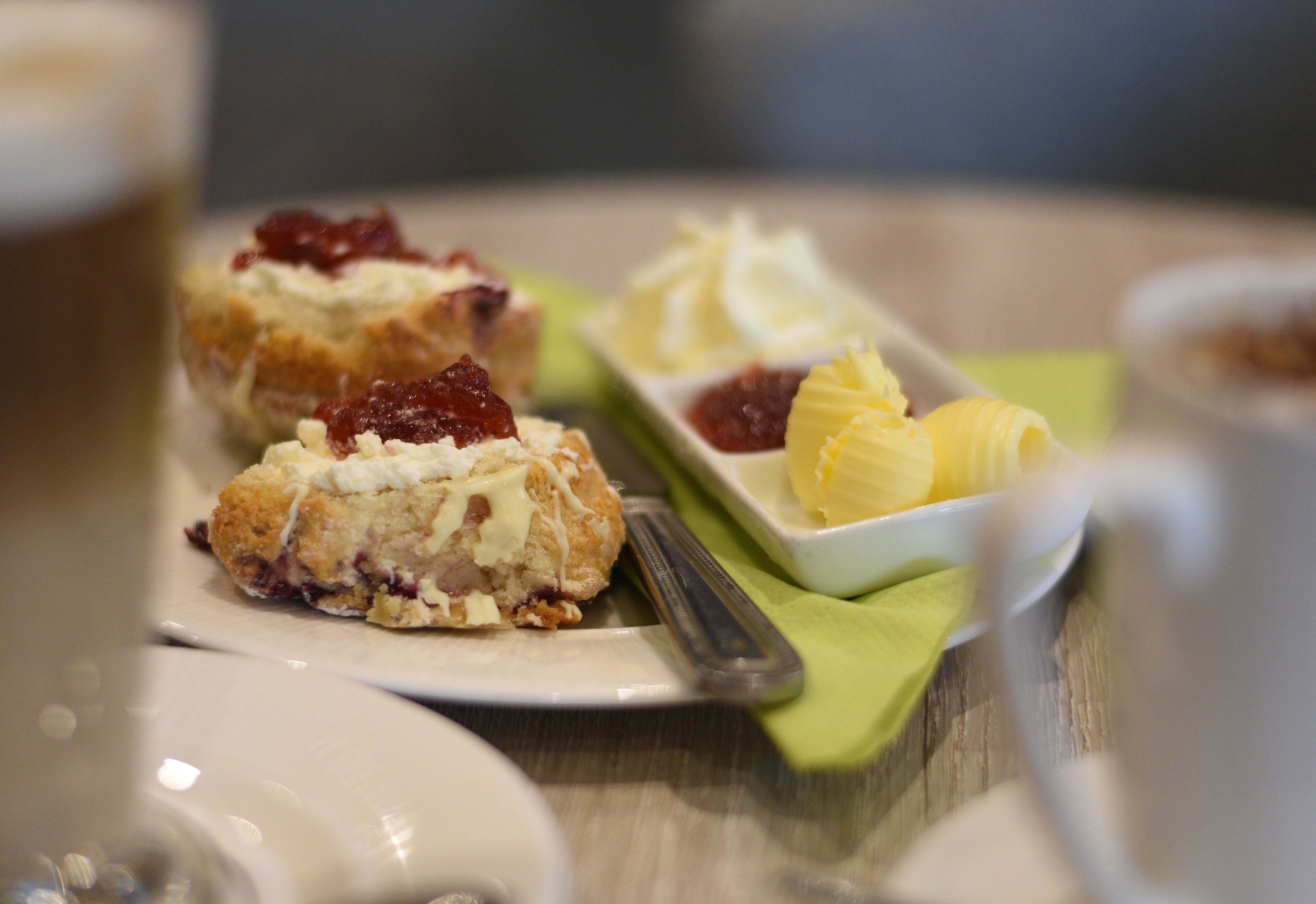 A plate with pastries and a small bowl of fruit on a table.