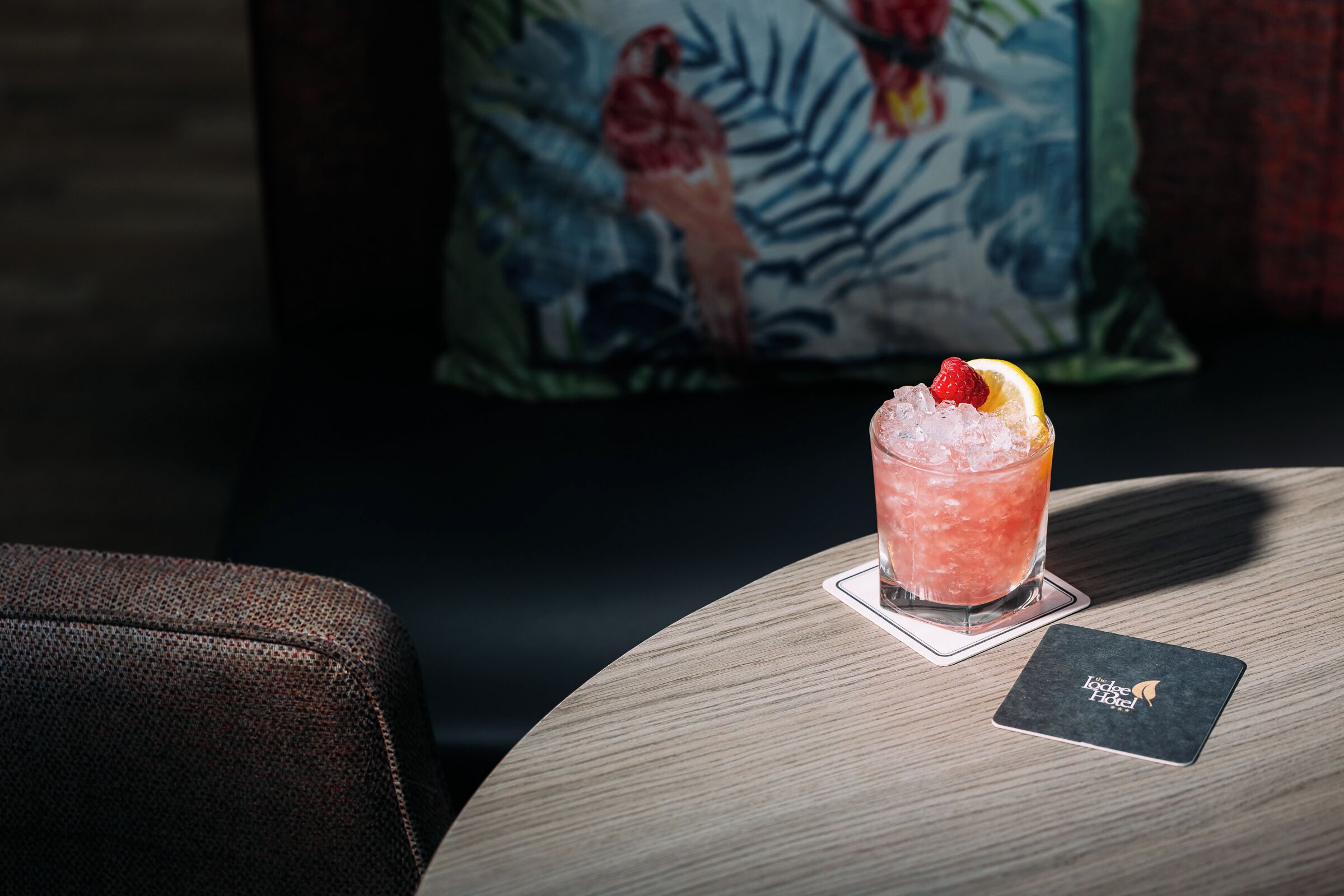 A cocktail on a coaster with a card beside it.