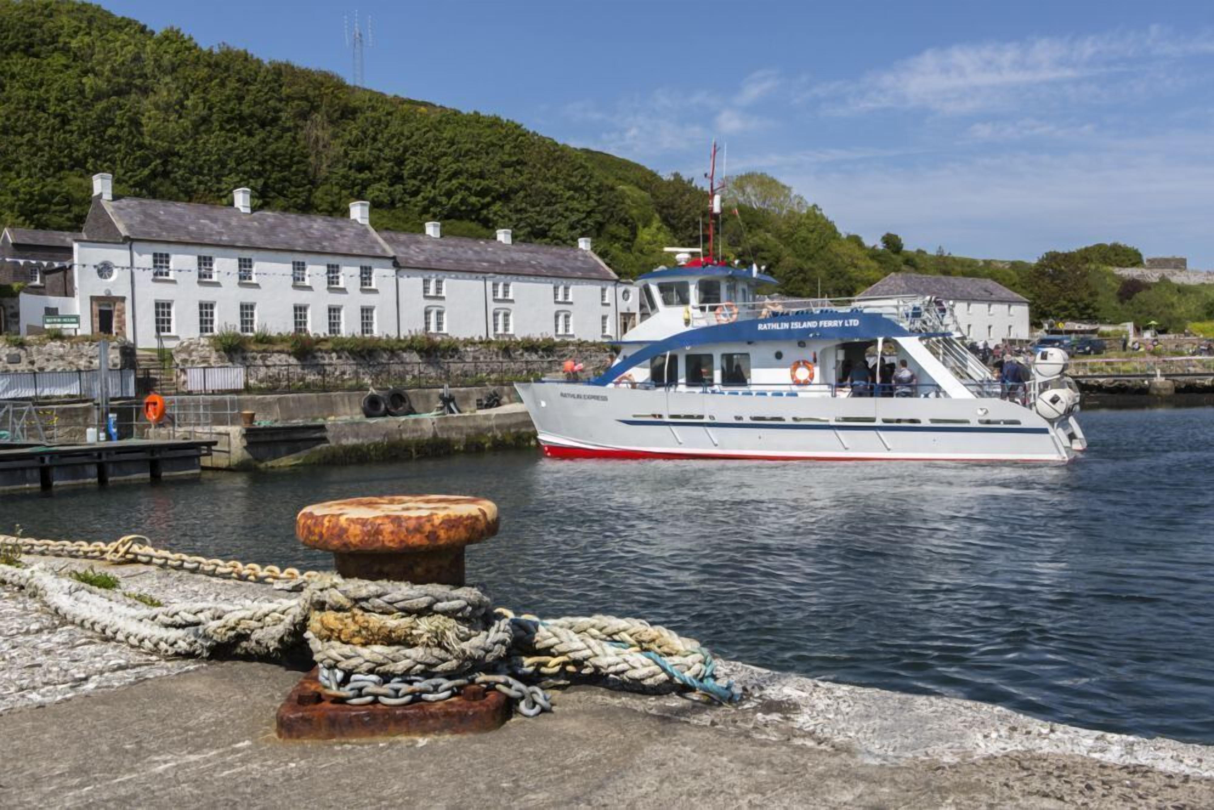 A boat docked at a harbor with a white building in the background.