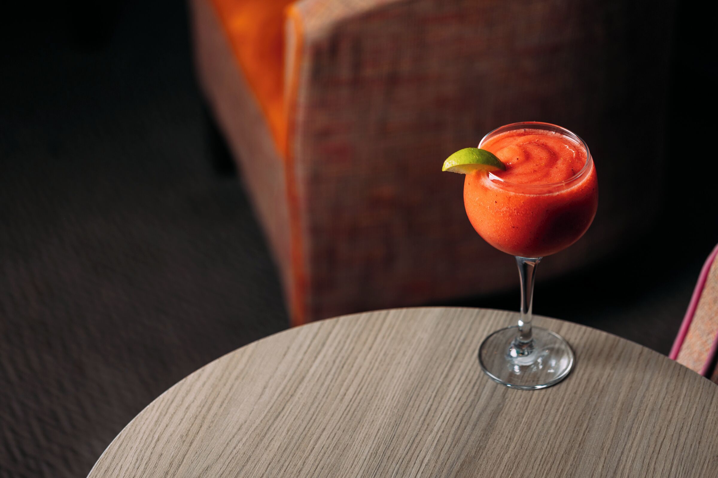 A cocktail in a glass on a round table.