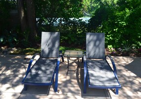 Una piscina al aire libre de temporada, sillones reclinables de piscina