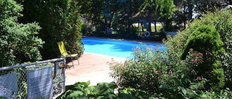 Piscine extérieure en saison, chaises longues