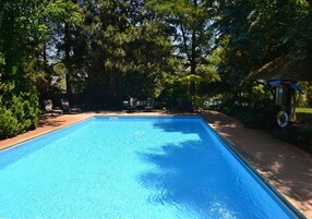 Una piscina al aire libre de temporada, sillones reclinables de piscina